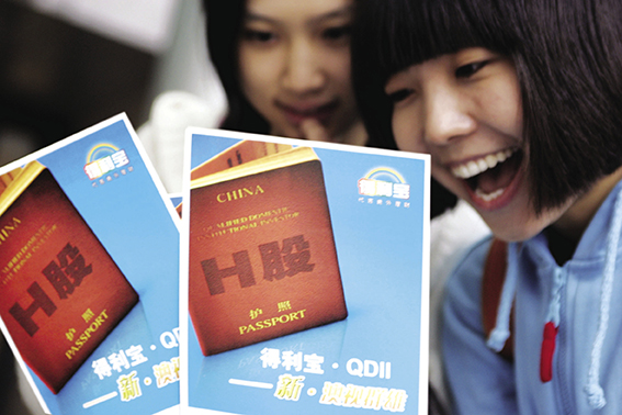 2007年12月30日，一女孩展示交通银行H股QDII理财宣传。其时，57只A+H股份的H/A比价均值跌至0.466，H股较对应A股的折价程度达到近年来最为严重的时段。