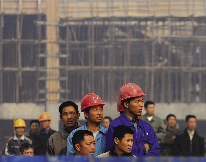 2007年11月8日，江苏省淮安某建筑工地工人在观看新厂房落成典礼