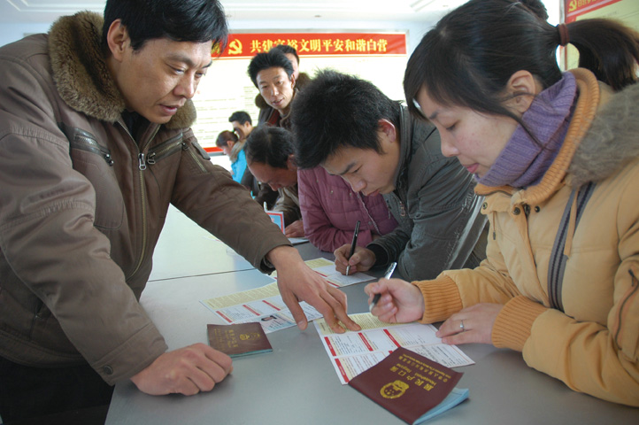 政府应不断完善农村金融政策。图为河南省返乡农民工正在办理小额创业贷款手续