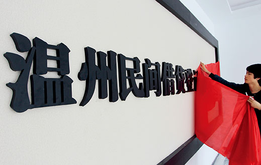 3月30日，在温州市江滨西路的一座大厦内，醒目的“温州民间借贷登记服务中心”铜字被镶嵌在墙上，工人正用红布将它盖起。