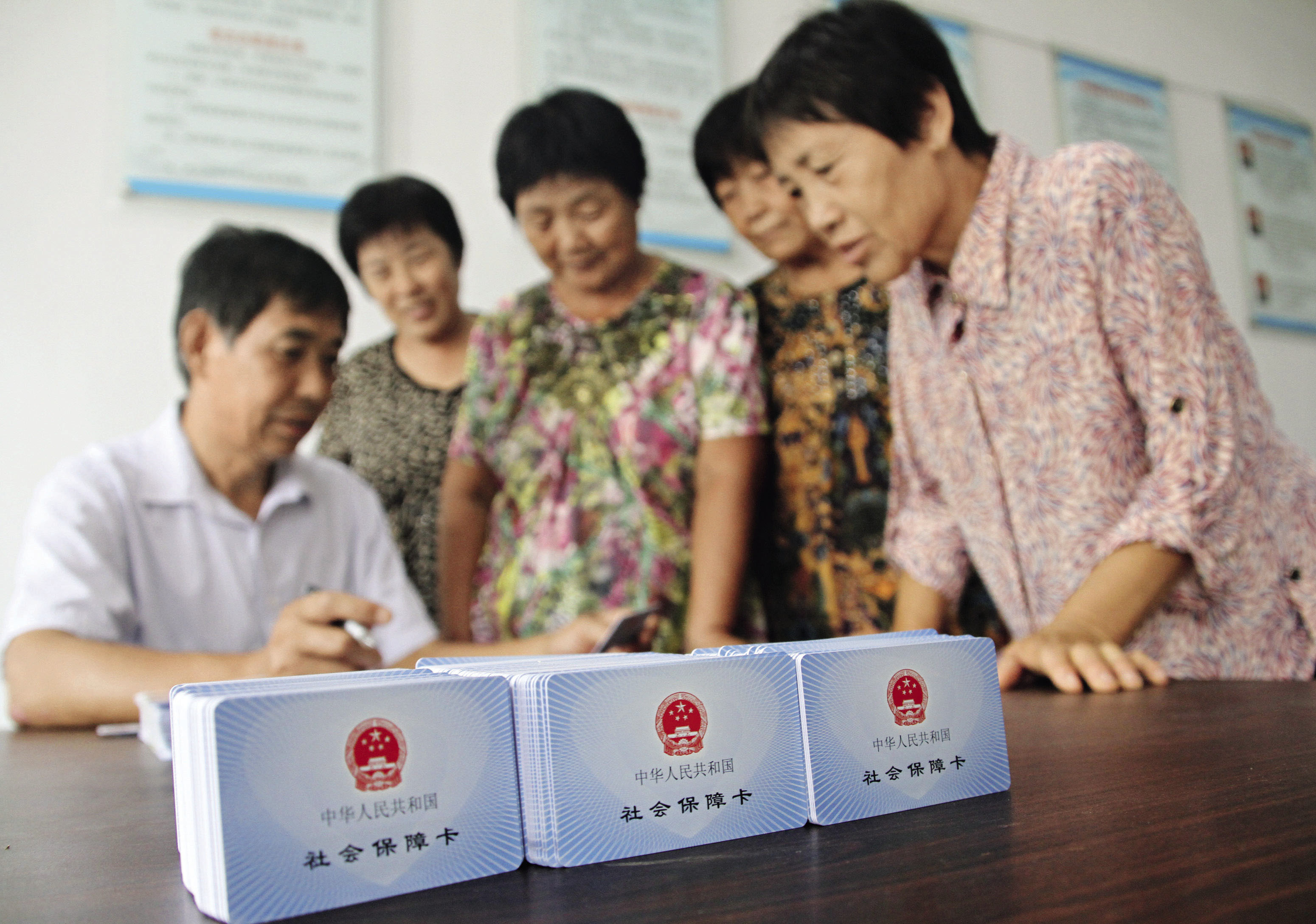 2016年8月19日，山东省博兴县纯化镇纯东村农民在村委会领取社会保障卡。