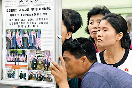 当地时间6月13日，朝鲜民众在平壤地铁站阅读有关朝美首脑会晤报道的当地报纸。