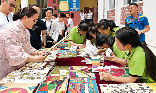 蒙古国对外关系部部长新闻代表拉瓦嘎苏仁·乌云通拉嘎（左）在黔西县中等职业学校观看学生的手工作品。　摄影/《中国报道》记者　张春侠