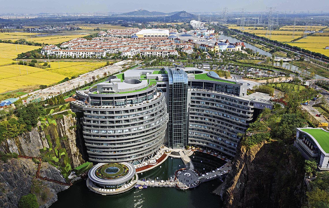位于上海佘山的世茂洲际酒店位于废弃矿坑中，依深坑崖壁而建，下探地表88米，地上2层、地下16层，面对瀑布幕墙，十分壮观。12年的潜心打磨，让采石留下的废弃深坑成为修复自然伤痕的“世界奇迹”酒店，实现建筑与自然的融合共生。