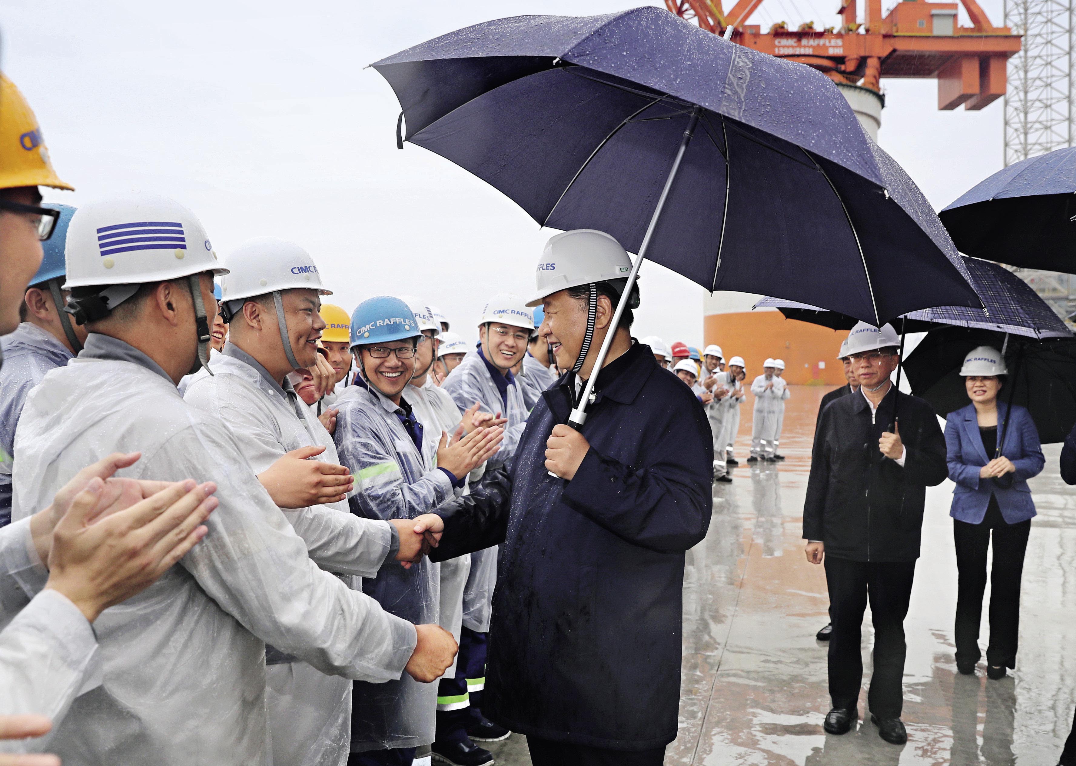 6月13日下午，习近平总书记在中集来福士海洋工程有限公司烟台基地，冒雨察看海洋工程设备建设场地，并同现场的工人们亲切握手。