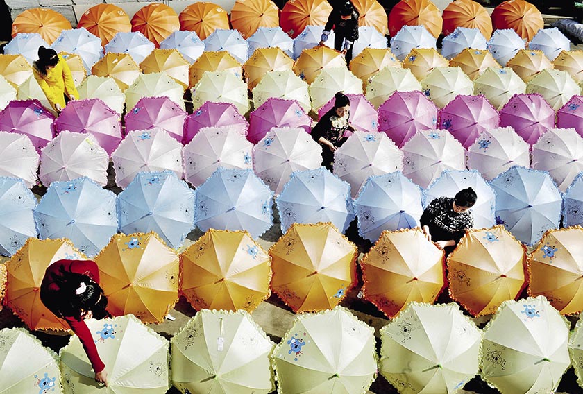 江西省德兴市万村乡沙畈村农民女工正在晾晒自己精心加工的新雨伞。