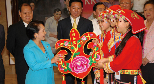 2009年1月16日，时任菲律宾总统阿罗约（前左）在首都马尼拉的总统府马拉卡南宫接见中国四川地震灾区中学生代表团，并接受羌族学生的礼物——带有“吉祥如意”四个字的红色羌绣吉祥包。