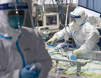 1月24日，在武汉大学中南医院重症隔离病房，医护人员为病人治疗。