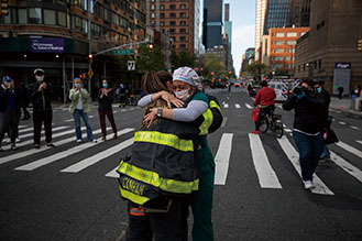 3．5月9日，在美国纽约一家医院外，一名纽约消防员与一名从阿拉巴马州前来支援的护士拥抱表示感谢。目前，美国累计新冠肺炎确诊病例超过140万例，累计死亡病例为85066例，确诊病例和死亡病例都是全球最多。