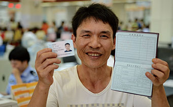 2014年9月21日，“福建第一县”晋江打造县域科学发展新范本。图为来自贵州的外来务工人员展示他新领的户口本和身份证。