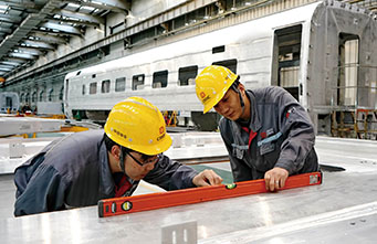 中车唐山机车车辆有限公司的工人在动车组生产线上工作。