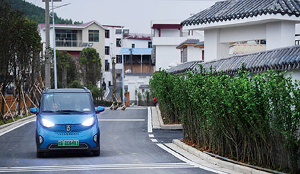 2018年4月25日，在广西柳州市柳东新区雒容镇果园村龙婆四队，村民开着新能源汽车行驶在沥青路上。