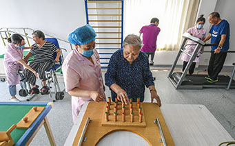 6月12日，在河北省廊坊市广阳区逸锦家苑社区居家养老服务中心，老人在医护人员的指导下进行康复训练。