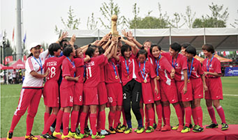 琼中女足多次获得“哥德杯中国”世界青少年足球赛冠军。图为球员们在颁奖典礼上举起冠军奖杯。