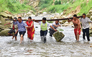 2017年6月30日，在位于黔桂交界的乌英苗寨，驻村第一书记韦桂华（右四）带领村民维修河堤。