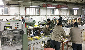 哈尔滨市石桥印务有限公司的厂房内，工作人员正在印刷、装订图书。